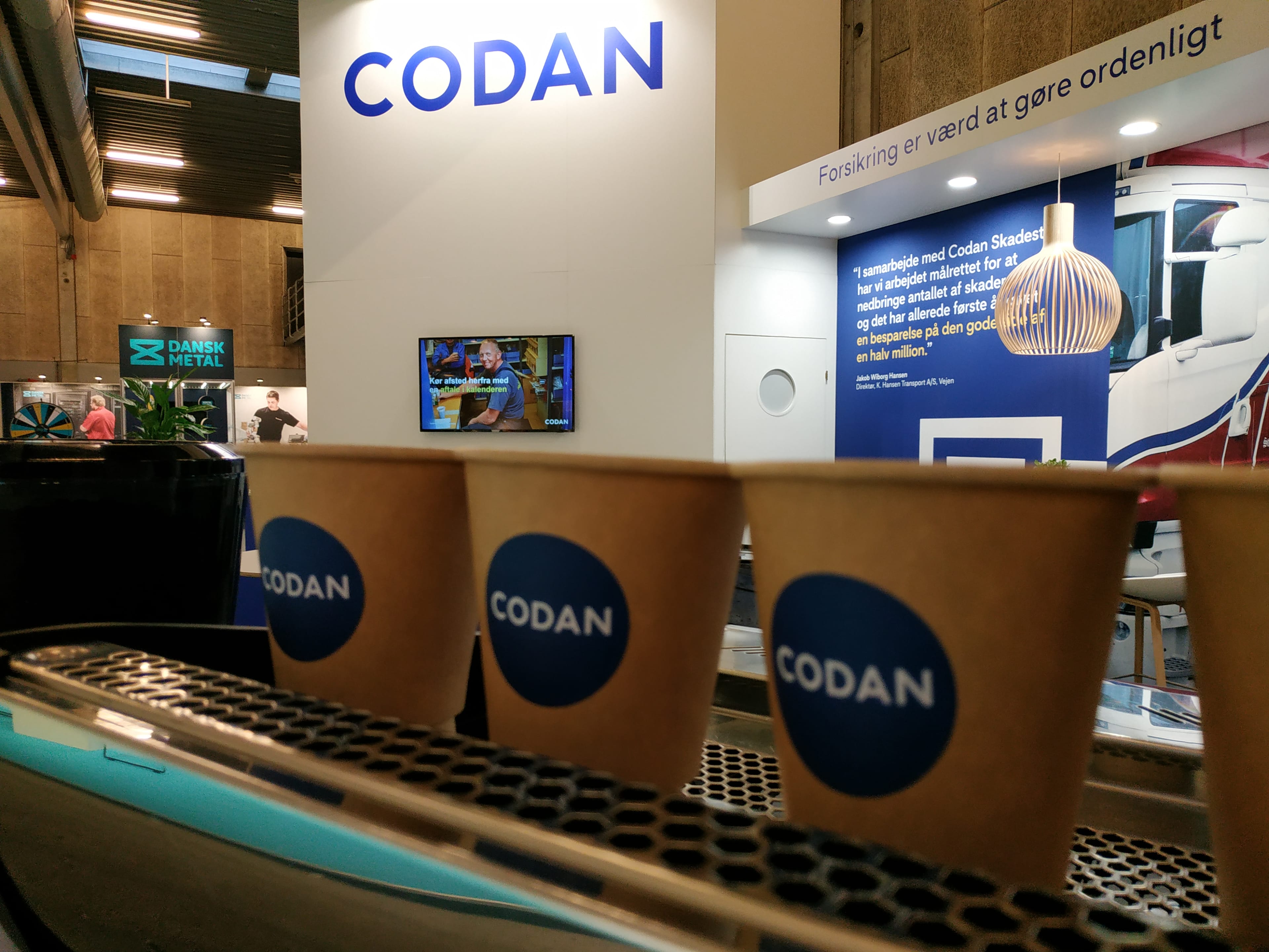 Branded kaffekop med Codan-logo — jeres logo direkte i hånden på kunden